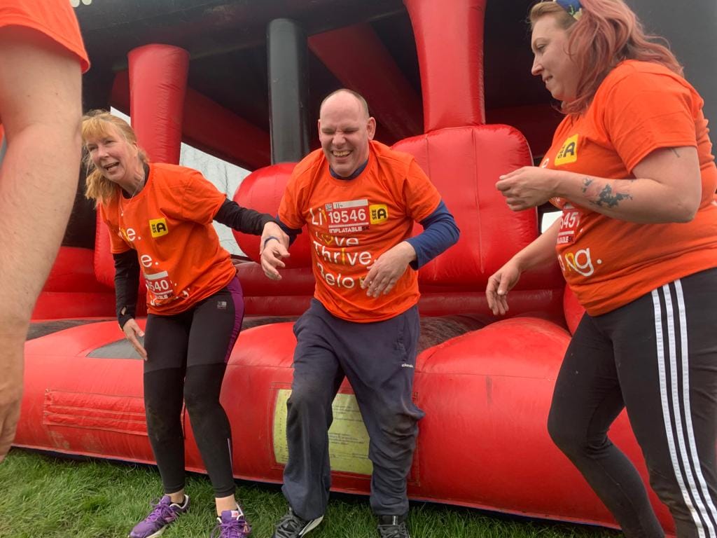 3 people on an inflatable course