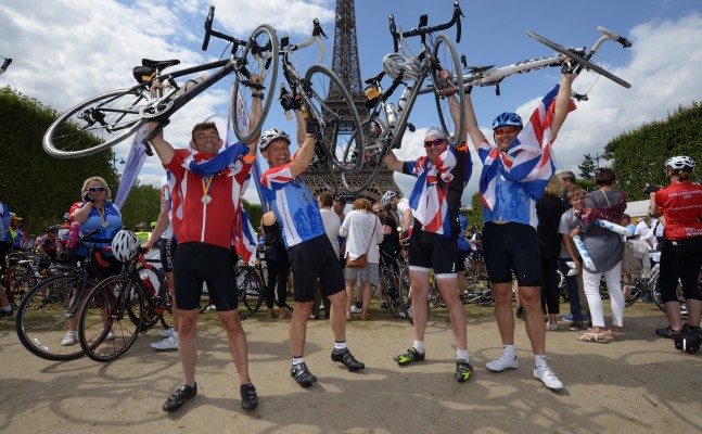 A group of people holding their bikes and cheering