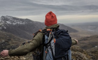 Person standing on the top of the 3 peaks looking over the mountains