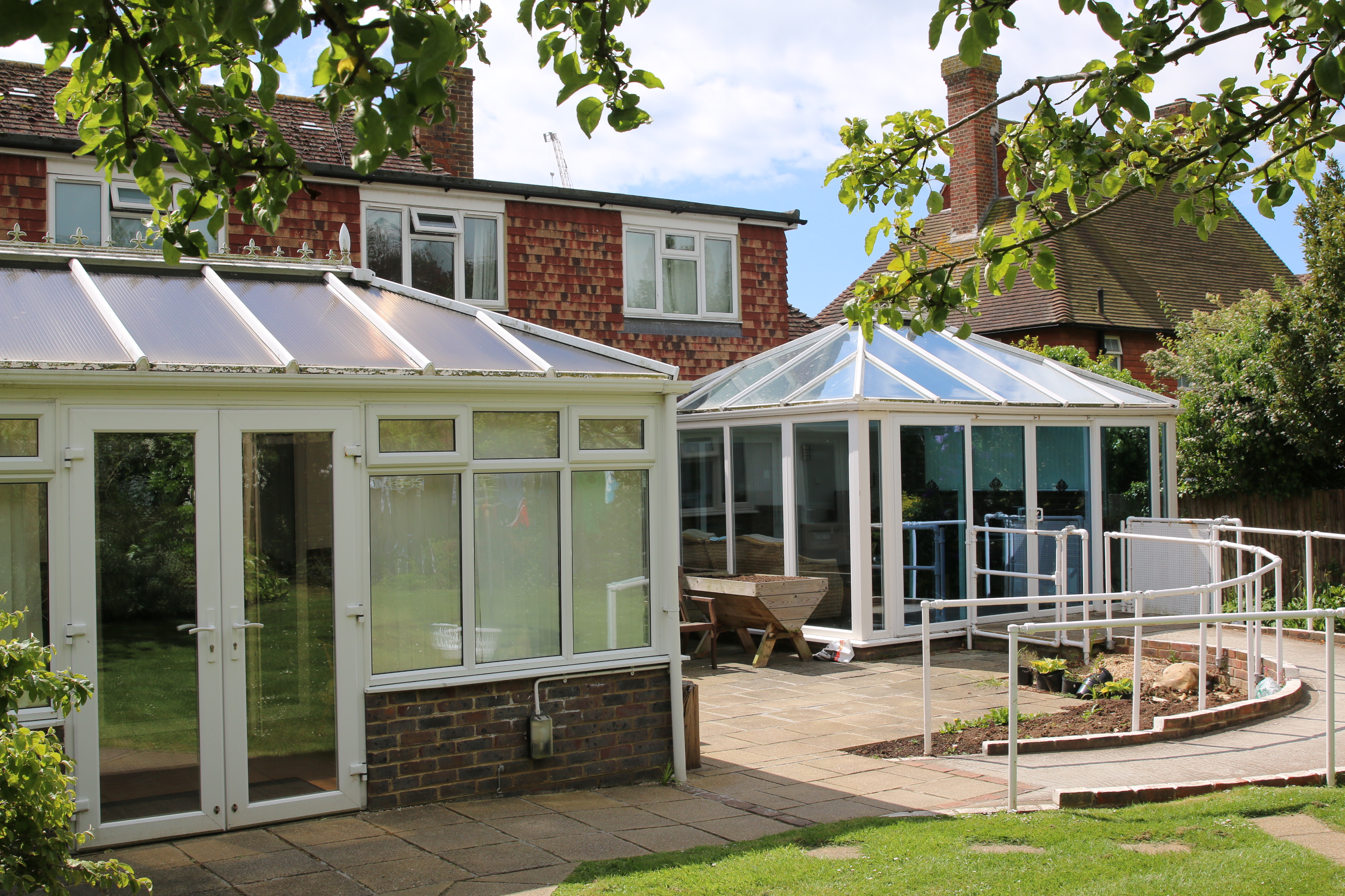 The outside of Applewood, showing a spacious conservatory within a peaceful and sunny garden.