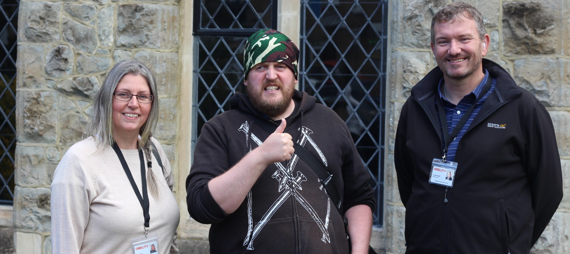 Ben giving a thumbs up next to his support workers