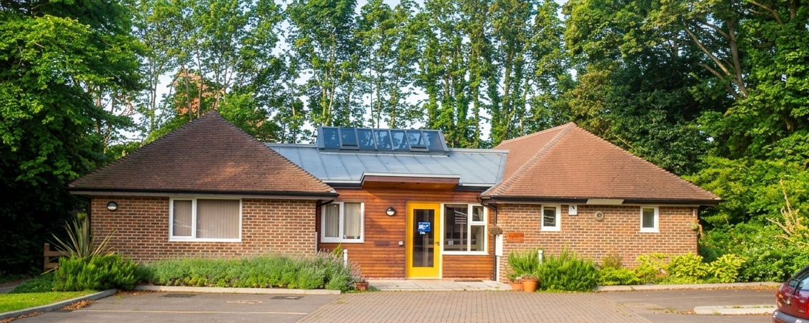 The outside of the Bradbury Centre, a single storey brick building with a central entrance and landscaped planting.