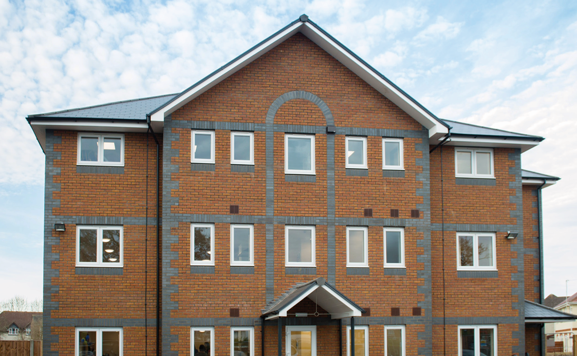 The outside of Buckinghamshire Support Service - a vibrant, modern brick home with three floors.