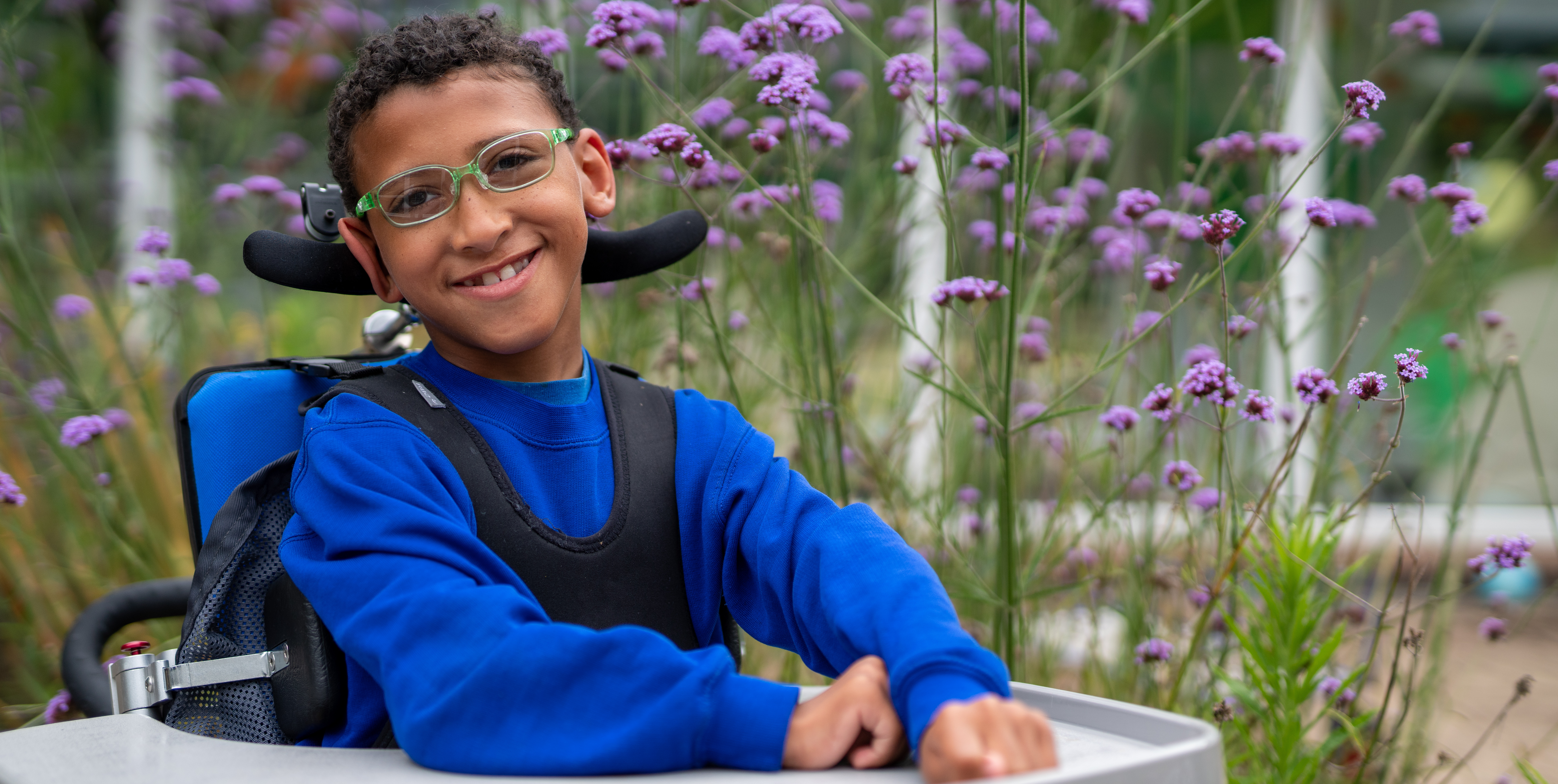A boy in glasses in a garden