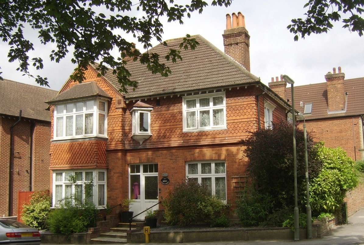 The outside of Denecroft, a traditional two-storey red-brick home.