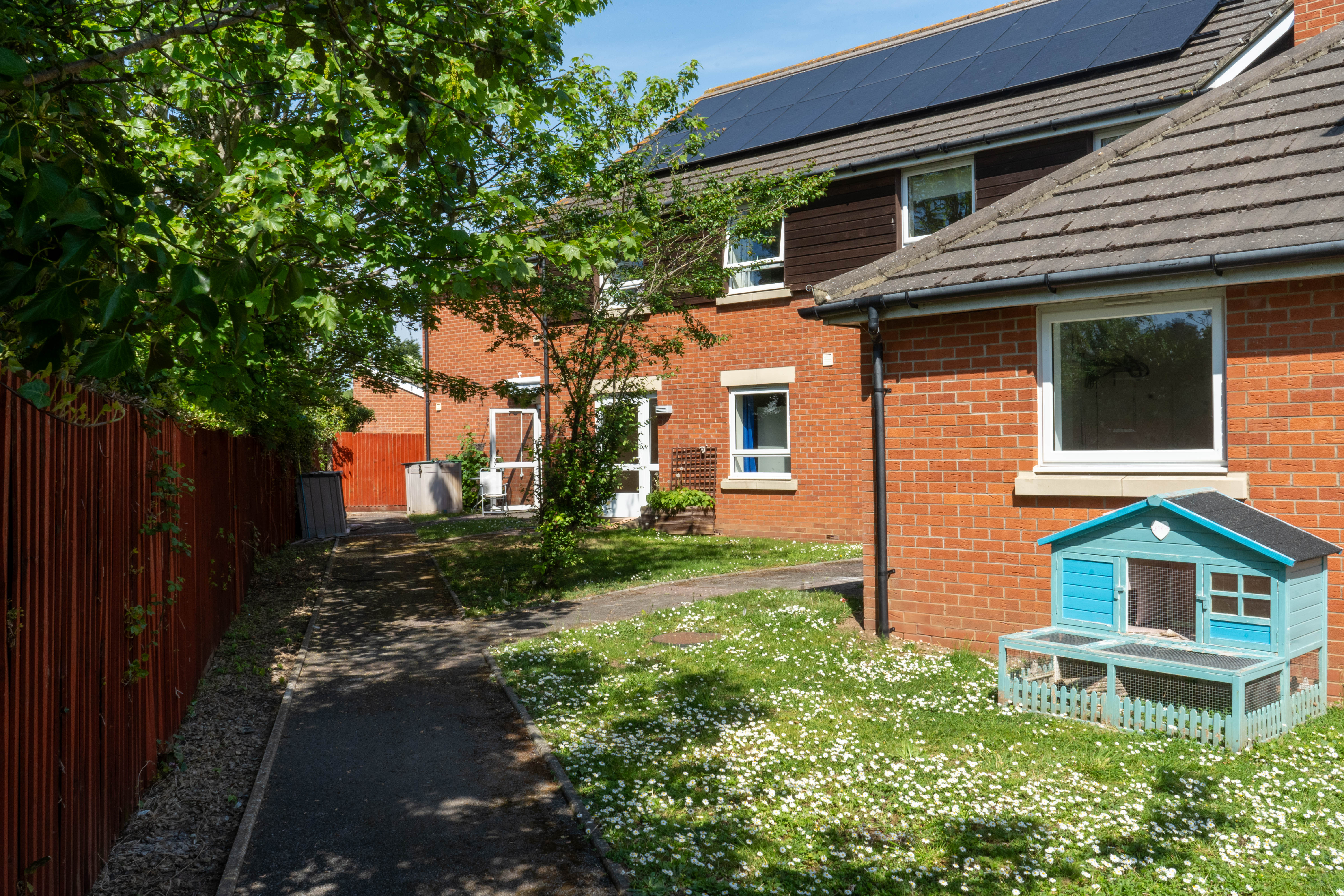 The outside of South Gloucestershire Support Service in Henbury - a bright, modern brick home with a sunny, peaceful green garden.
