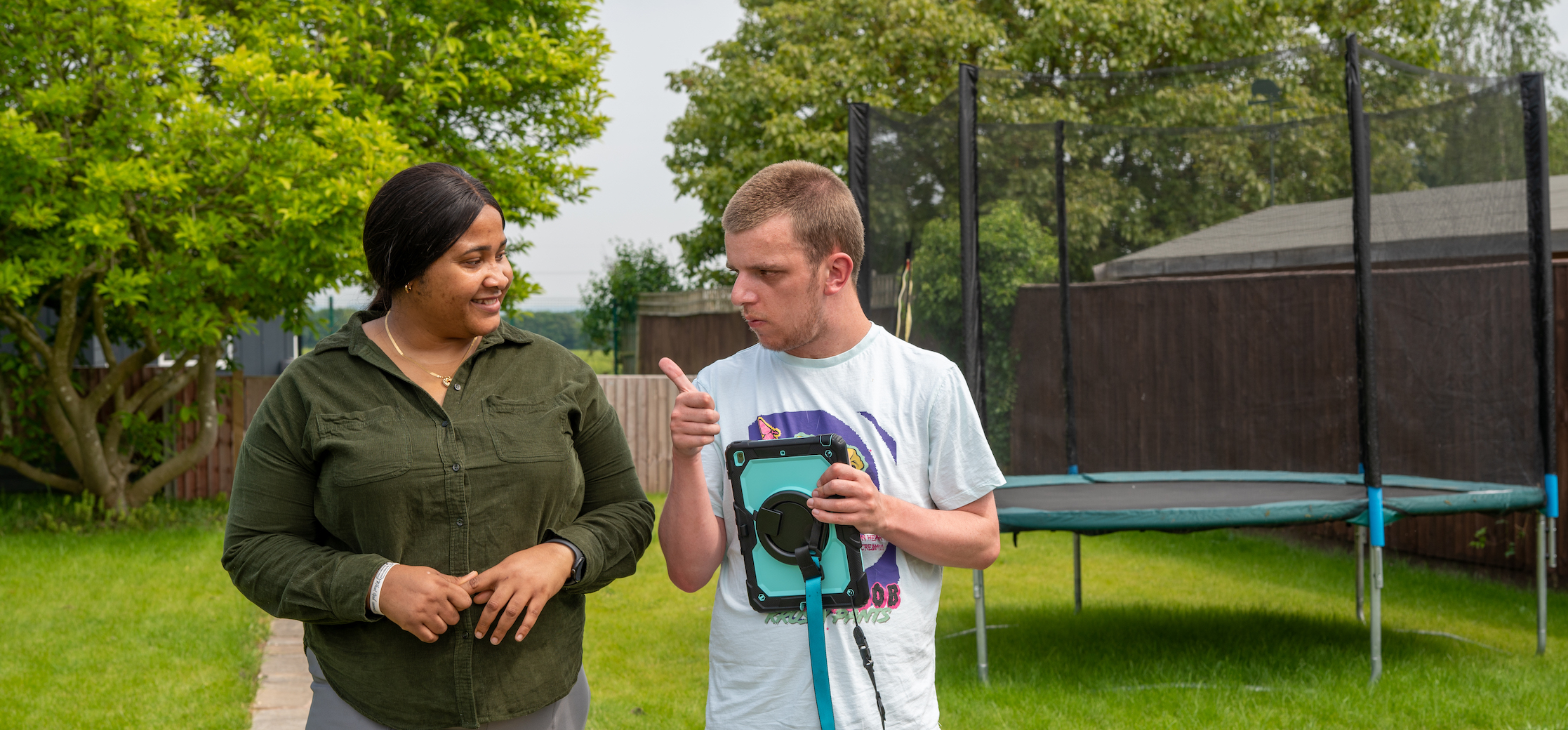 Jake walking in his garden with a support worker