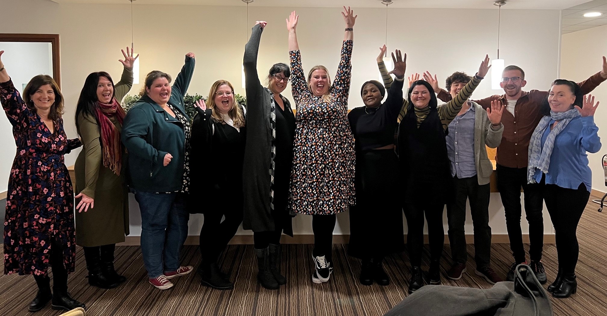 A group of mostly female SeeAbility employees cheering