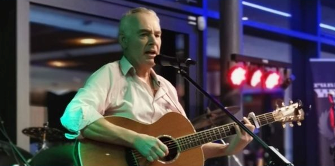 Nigel Waite playing guitar on stage