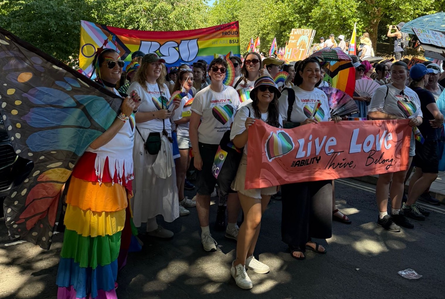 The team in the Pride march all smiling and wearing rainbow accessories
