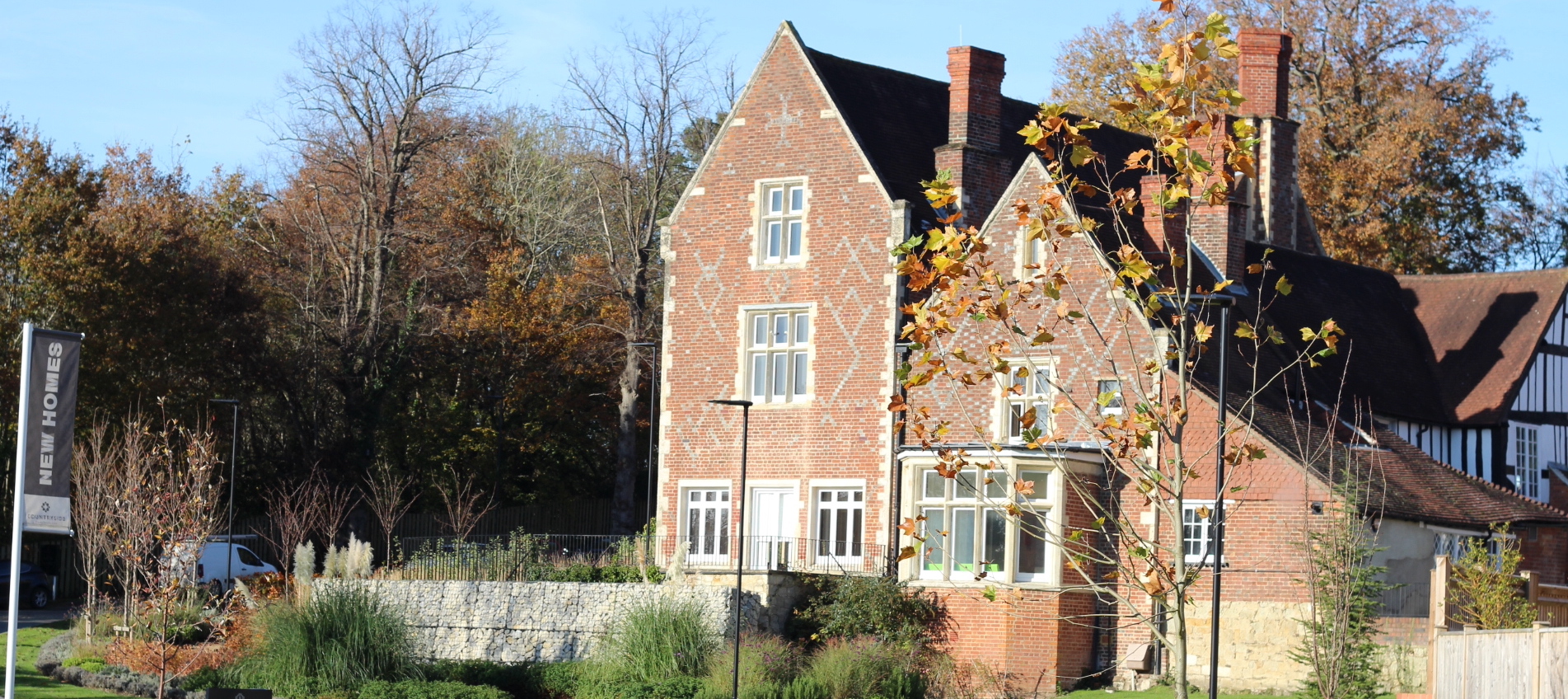The outside of Tudor House in Redhill - a red-brick home set within green countryside surroundings.