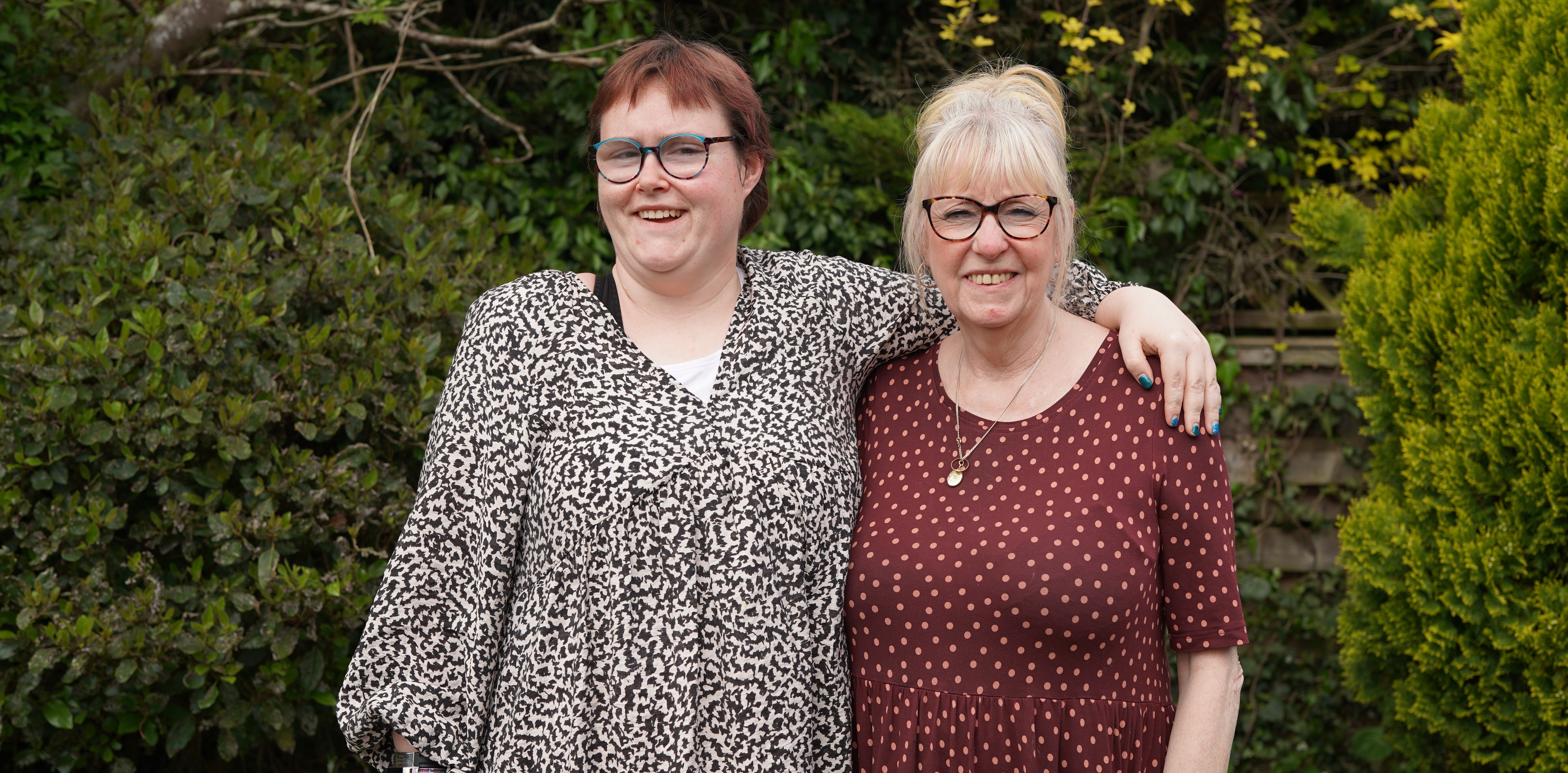 Grace smiling in the garden with a support worker