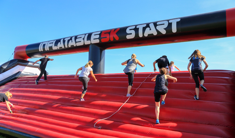People running up huge red inflatable stairs