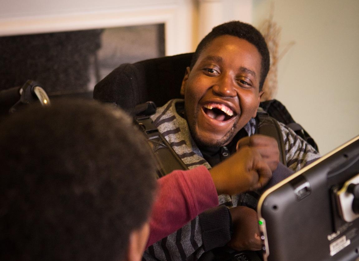 Sadick grins at his key worker over his eye-gaze screen