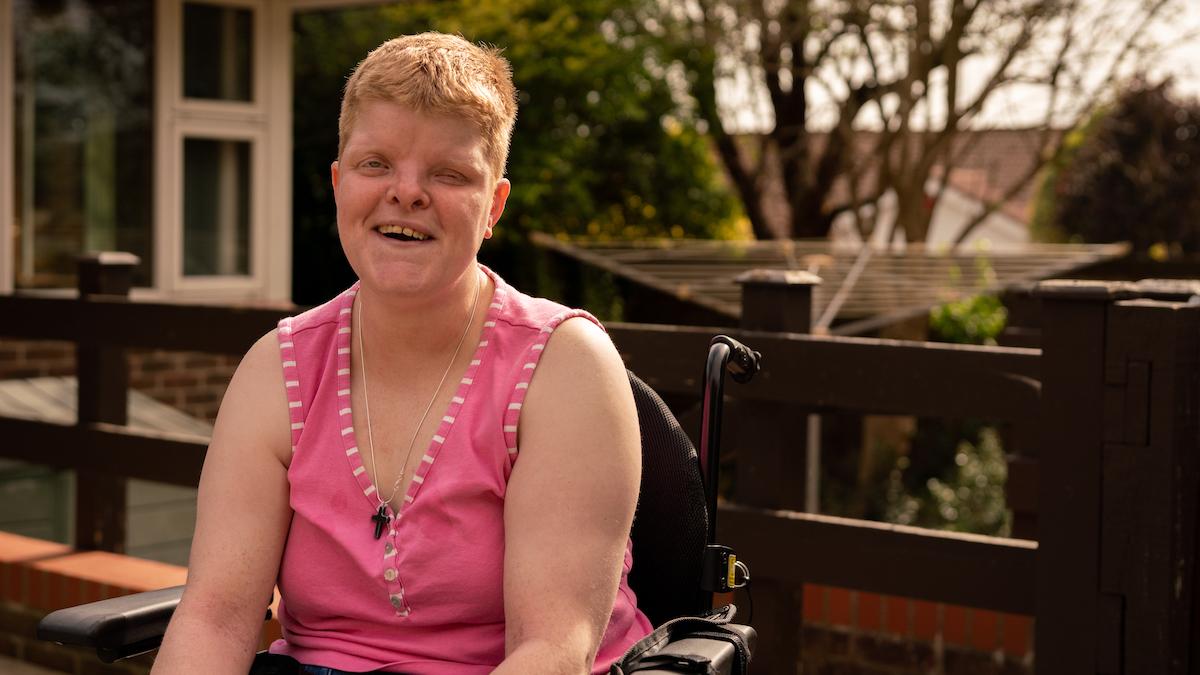 Emily wears a pink top and has a big smile