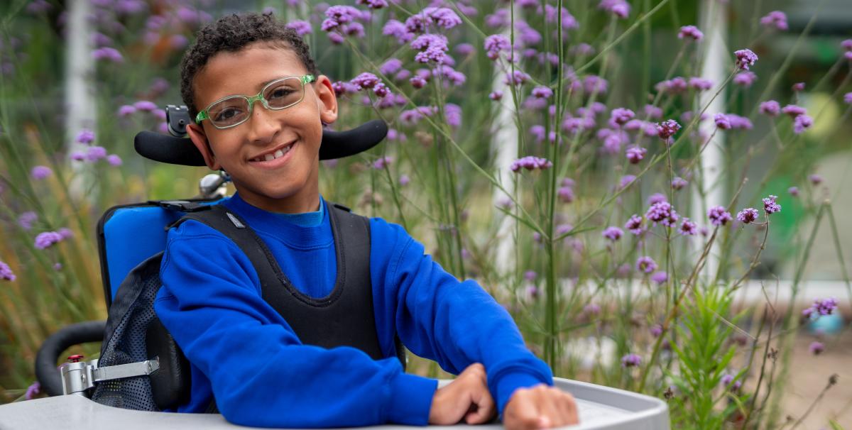 A boy in glasses in a garden