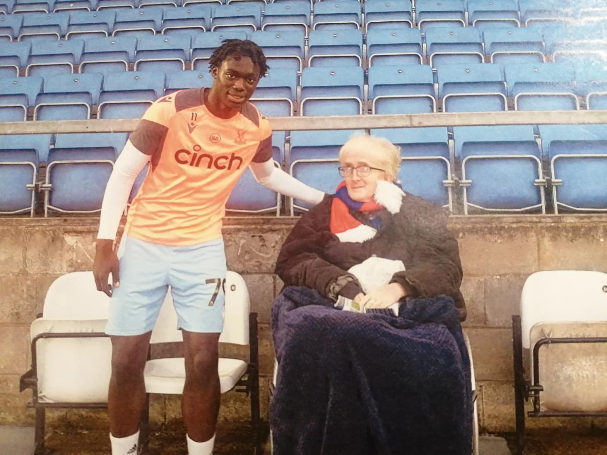 Julian at a Crystal Palace game with one of the football players 