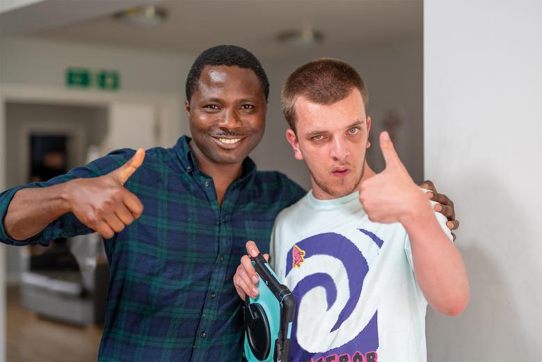 Jake and his support worker giving a thumbs up to the camera