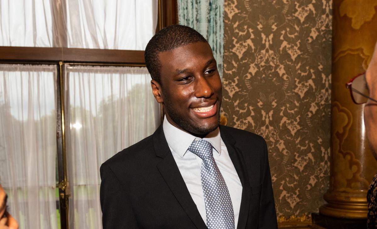 Lance wearing a suit at Buckingham Palace