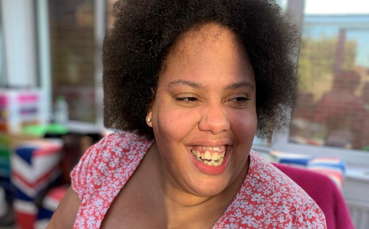 Tamika smiling and wearing a pink flowery top