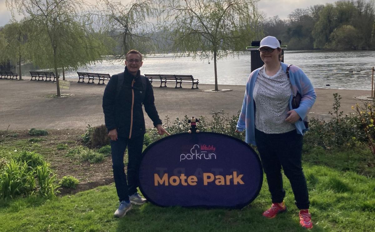 Grace and her running buddy standing in a park smiling