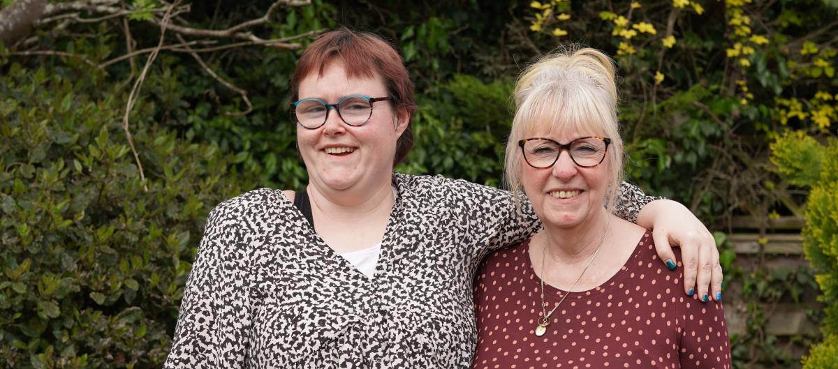 Grace and her support worker smiling