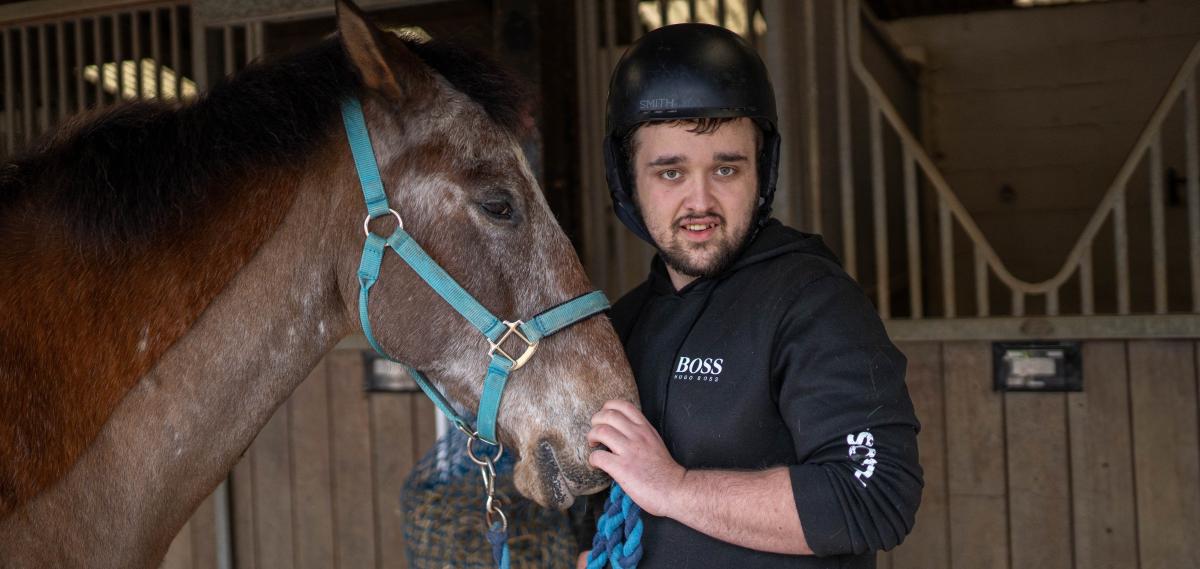 Charlie smiling with a horse at HorseWorld, a charity in Bristol