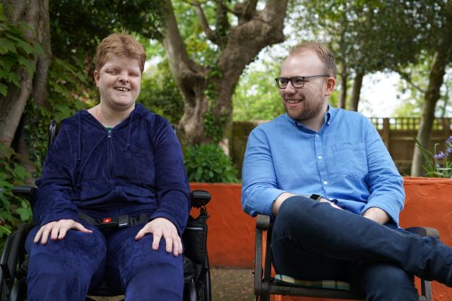 Emily and Lewis sitting on a bench and smiling