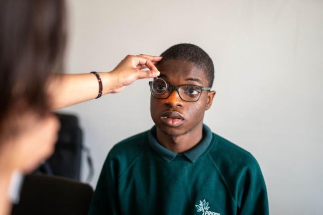 Adeboye having an eye test in his school uniform