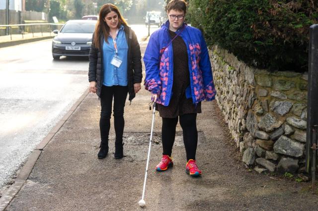 Grace and her supporter Sam doing long cane training in the street