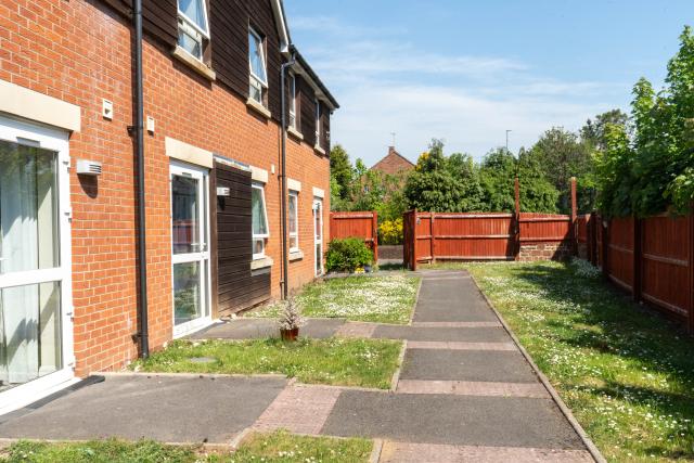 The outside of some of our apartments at Henbury, showing a walkway leading through a shared garden area.
