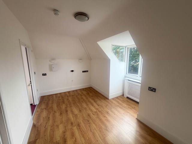 A bedroom in Surbiton, showing a bright open space with laminate flooring. 
