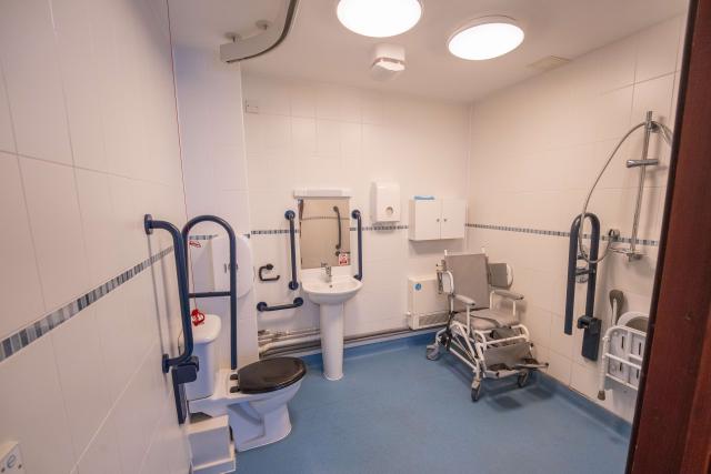 A fully accessible wet room at The Willows, showing a toilet, sink, and showering area.