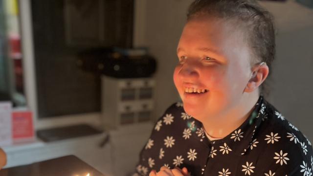 Kayleigh smiling in candlelight