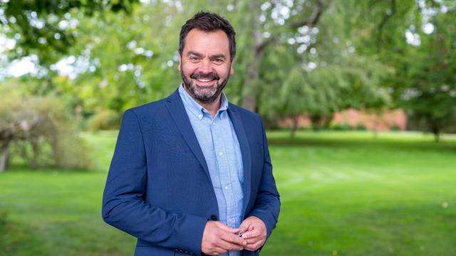 Paul Pargeter smiling at Hampton Court while wearing a blue blazer and shirt