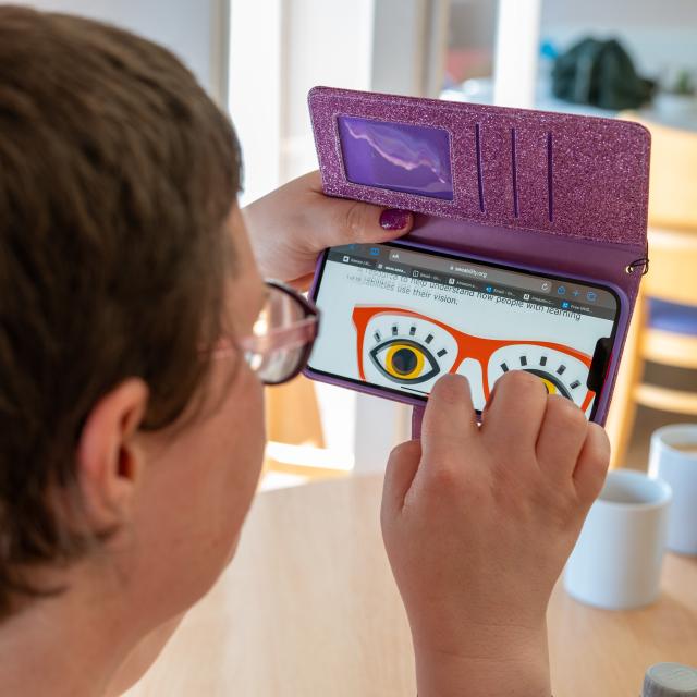 Grace reading one of our resources on her mobile phone