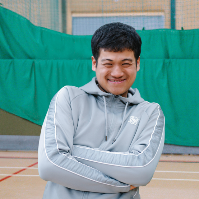 Giban with his arms crossed smiling cheekily at the camera