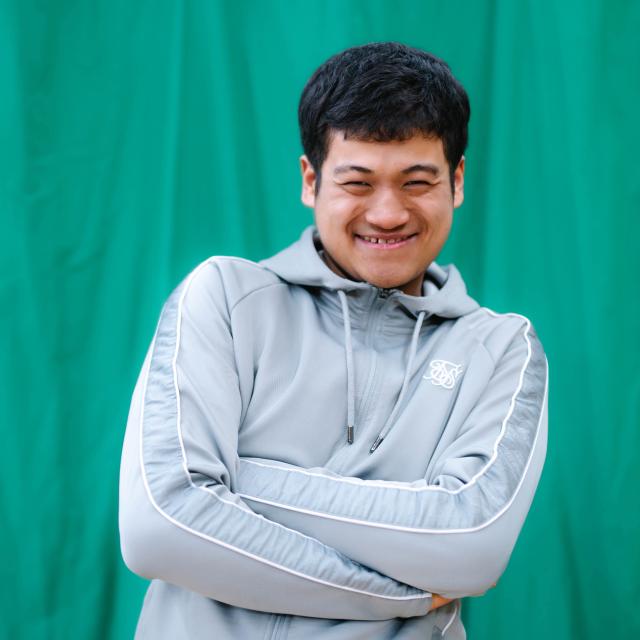 Giban crossing his arms and smiling at the camera