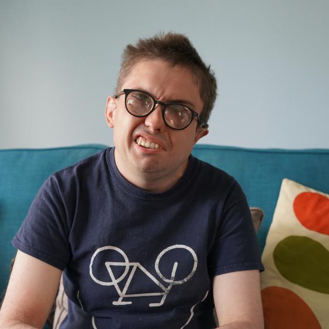 David sitting in his flat