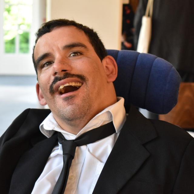 Danny wearing a suit and smiling