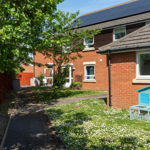 The outside of South Gloucestershire Support Service in Henbury - a bright, modern brick home with a sunny, peaceful green garden.