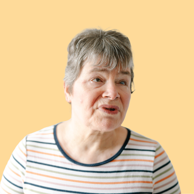 Caroline smiling with a yellow background