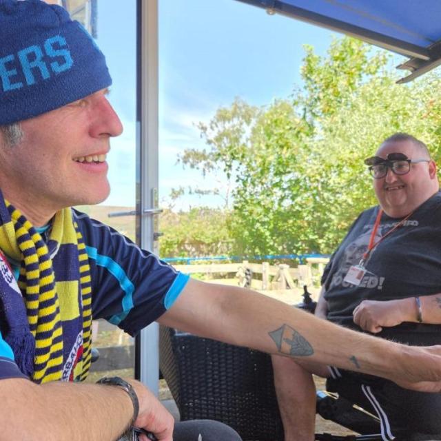 Andrew and Scott sitting together and smiling