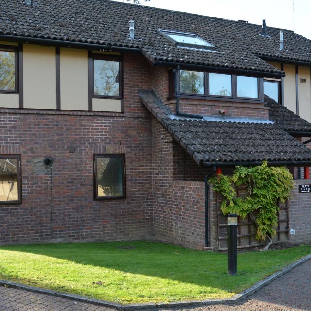 The outside of Spencer Court in Leatherhead, showing a large inviting building with a lawn at the front.