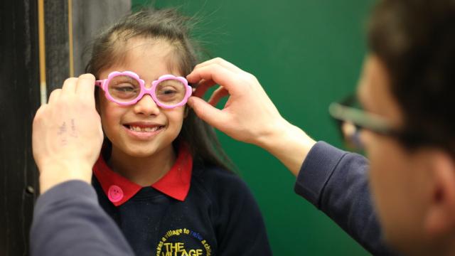 Kiyana smiles while having her glasses fitted