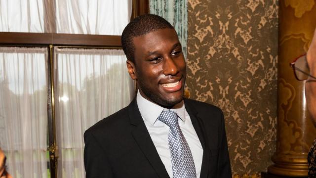 Lance wearing a suit at Buckingham Palace