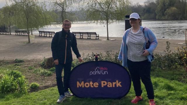 Grace and her running buddy standing in a park smiling