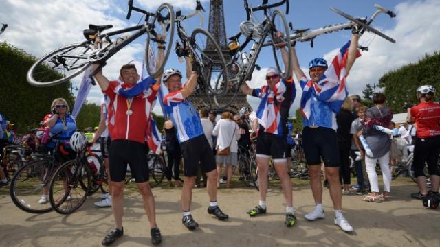 A group of people holding their bikes and cheering