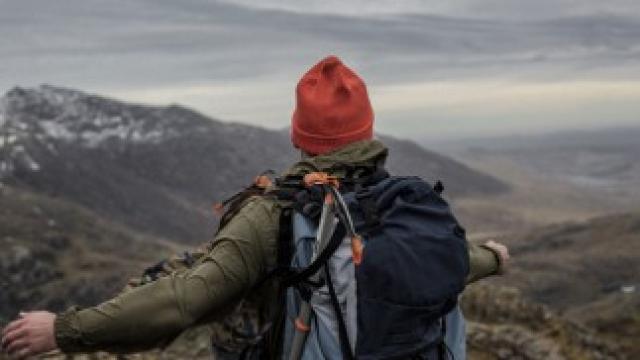 Person standing on the top of the 3 peaks looking over the mountains