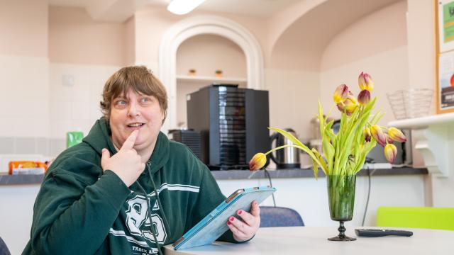 Jan in her kitchen using an iPad